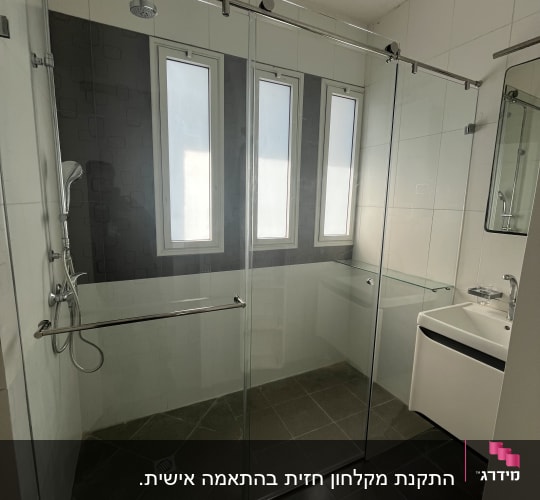 מקלחון זכוכית עם ראש מקלחת וכיור בחדר אמבטיה מודרני